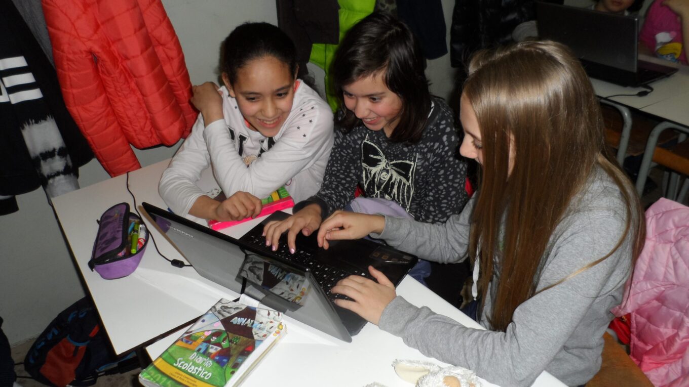 tre studentesse davanti al PC in classe che si esercitano con Scratch